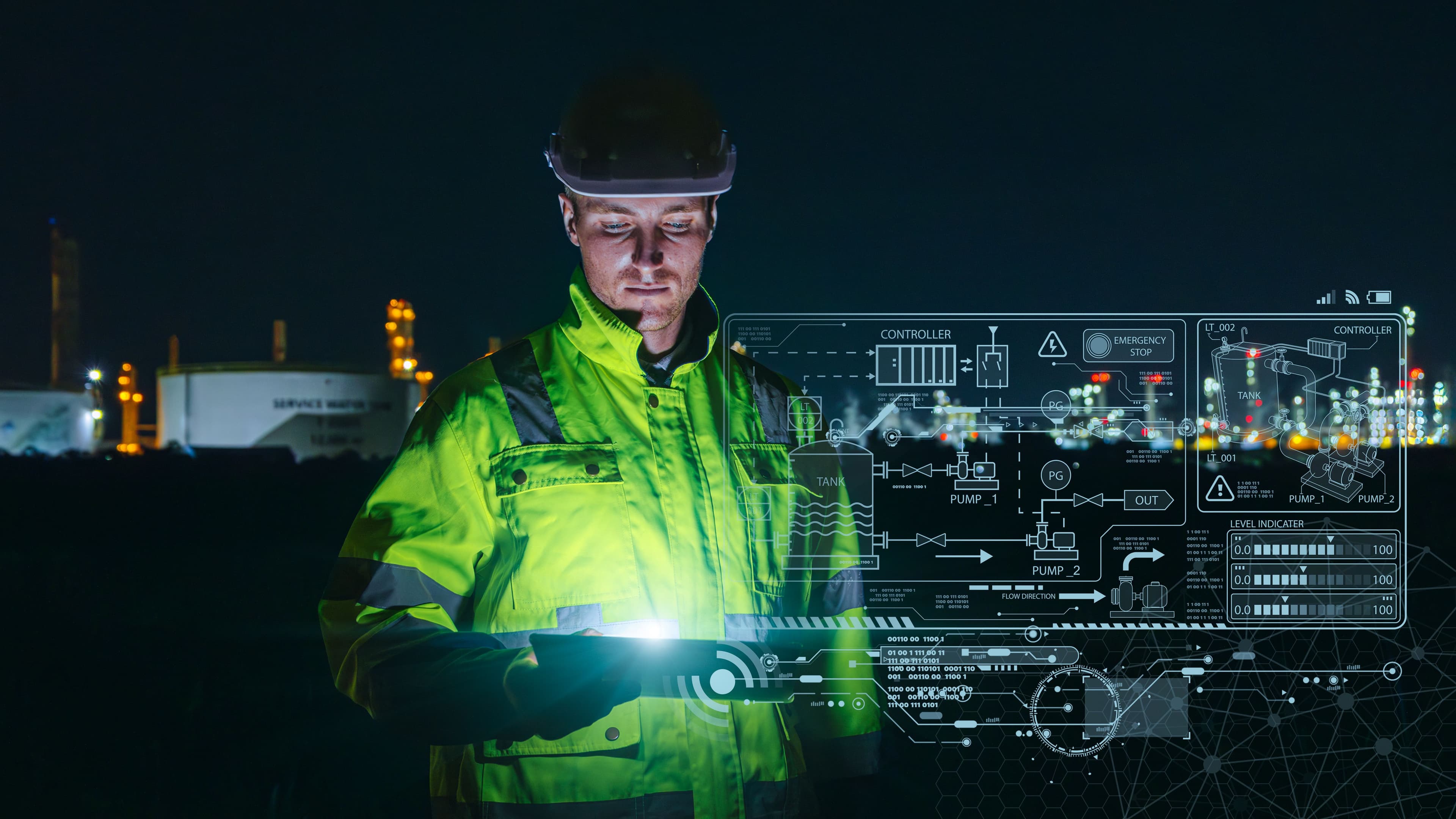 Engineer in high-vis jacket using a tablet with a digital schematic overlay at night.